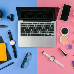 top view of laptop, smartphone and cosmetics with office supplies divided at male and female